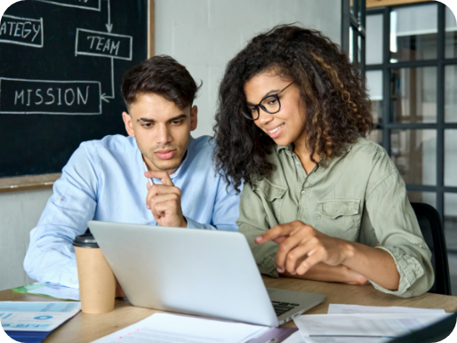 People at a desk looking at a laptop