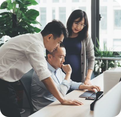 Employees at a desk looking at a computer