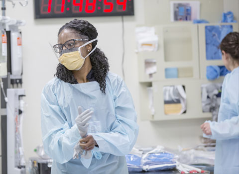 Hospital worker putting on gloves