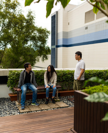 Three people talking in courtyard