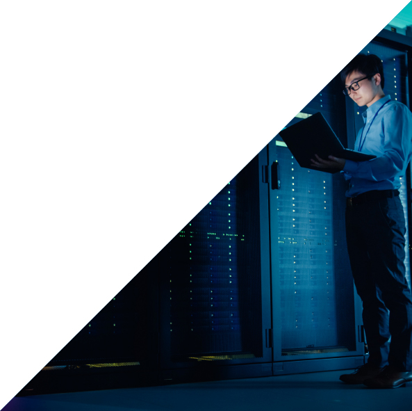 Man with laptop standing in front of servers