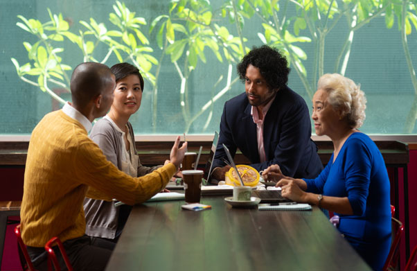 Four people at a table having a meeting